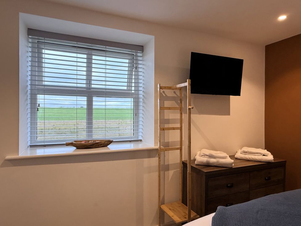 A bedroom with a window and television at The Barn in Wigglesworth near Settle