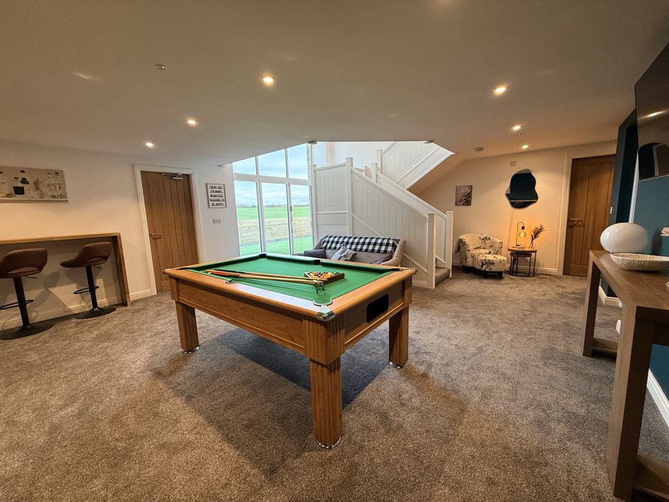 A recreation room with a pool table and seating areas at The Barn in Wigglesworth near Settle