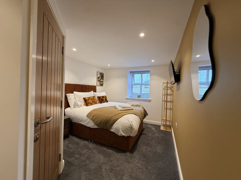A bedroom with a bed and television at The Barn in Wigglesworth near Settle