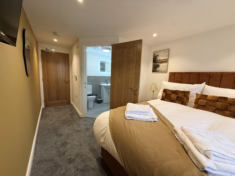 A bedroom with towels on the bed and an adjoining bathroom at The Barn in Wigglesworth near Settle