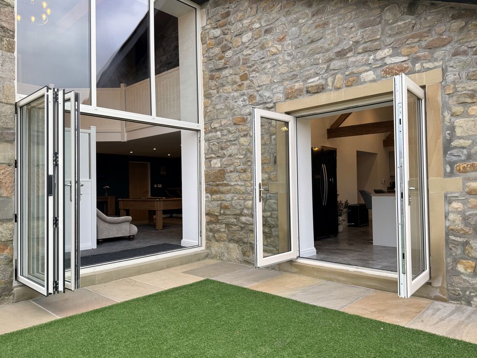 An outdoor area with bi-fold doors leading to an indoor space at The Barn in Wigglesworth near Settle
