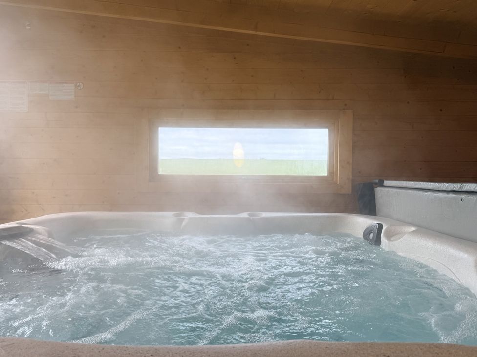 A hot tub with steam and a window at The Barn in Wigglesworth near Settle