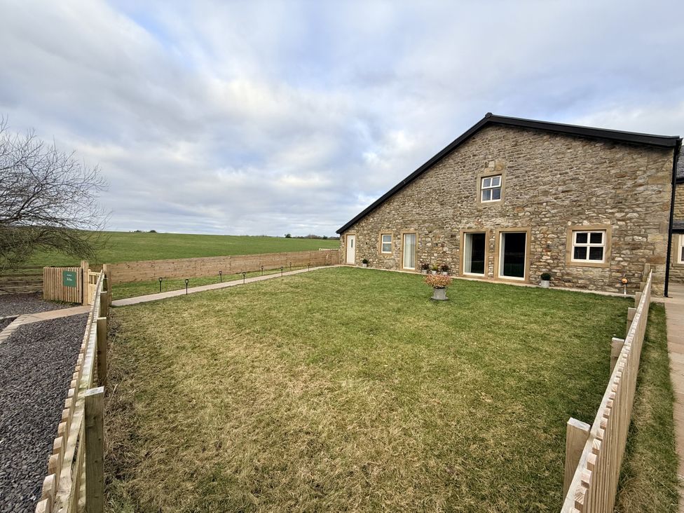 An outdoor area with grass and a stone building at The Barn in Wigglesworth near Settle