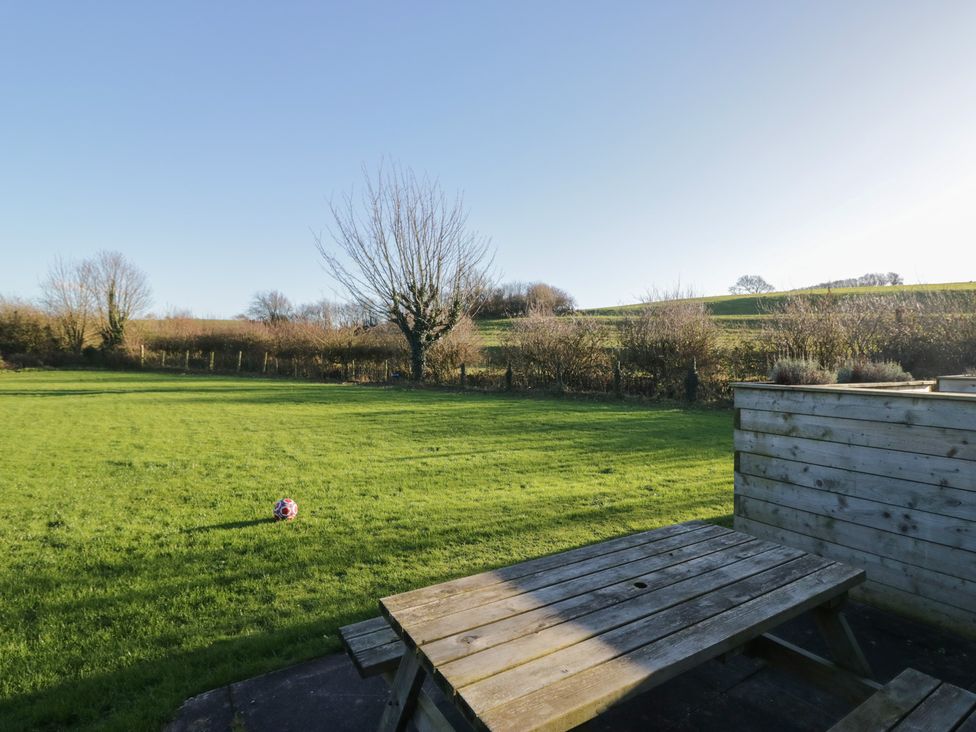 A garden with grass and a bench at Low Greenlands House in Tewitfield