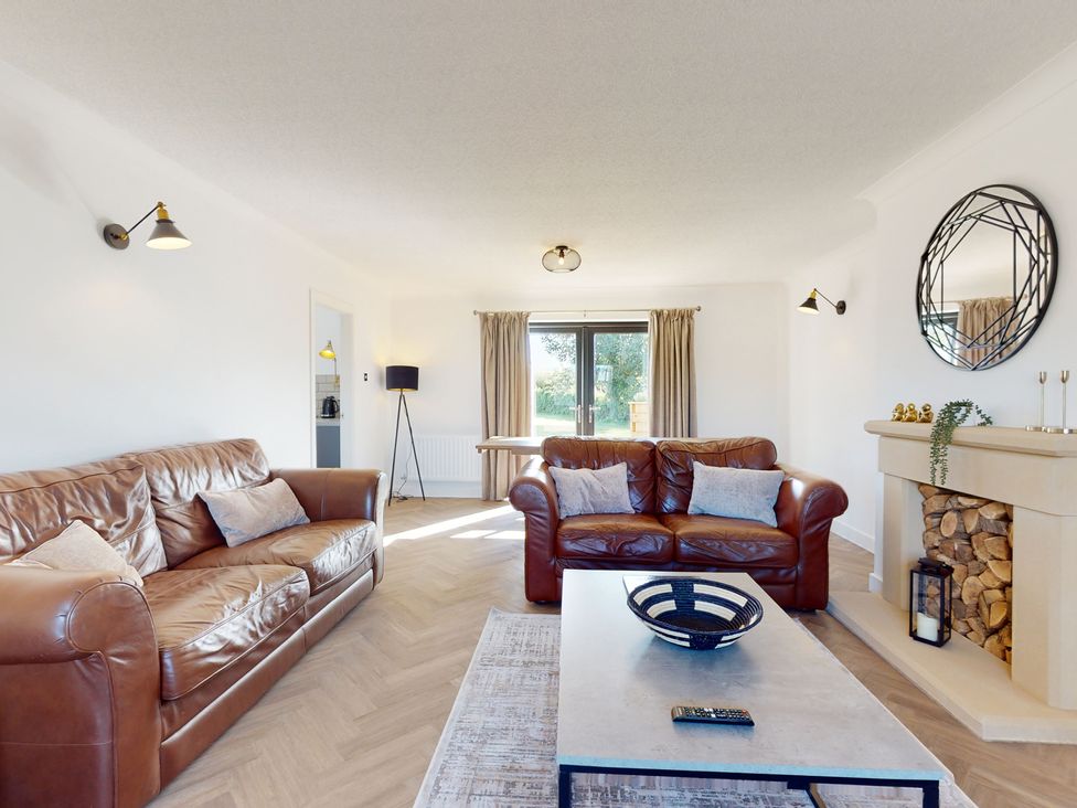 A living room with sofas and a fireplace at Low Greenlands House in Tewitfield