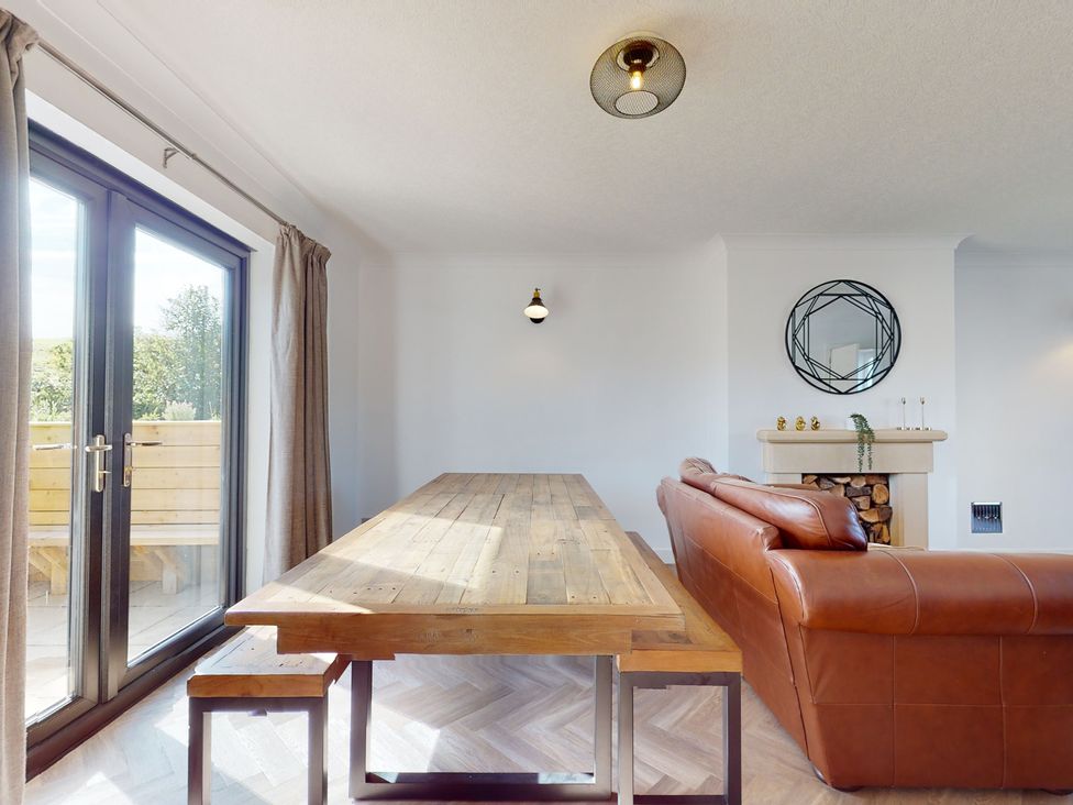 A dining room with a table and a sofa at Low Greenlands House Tewitfield