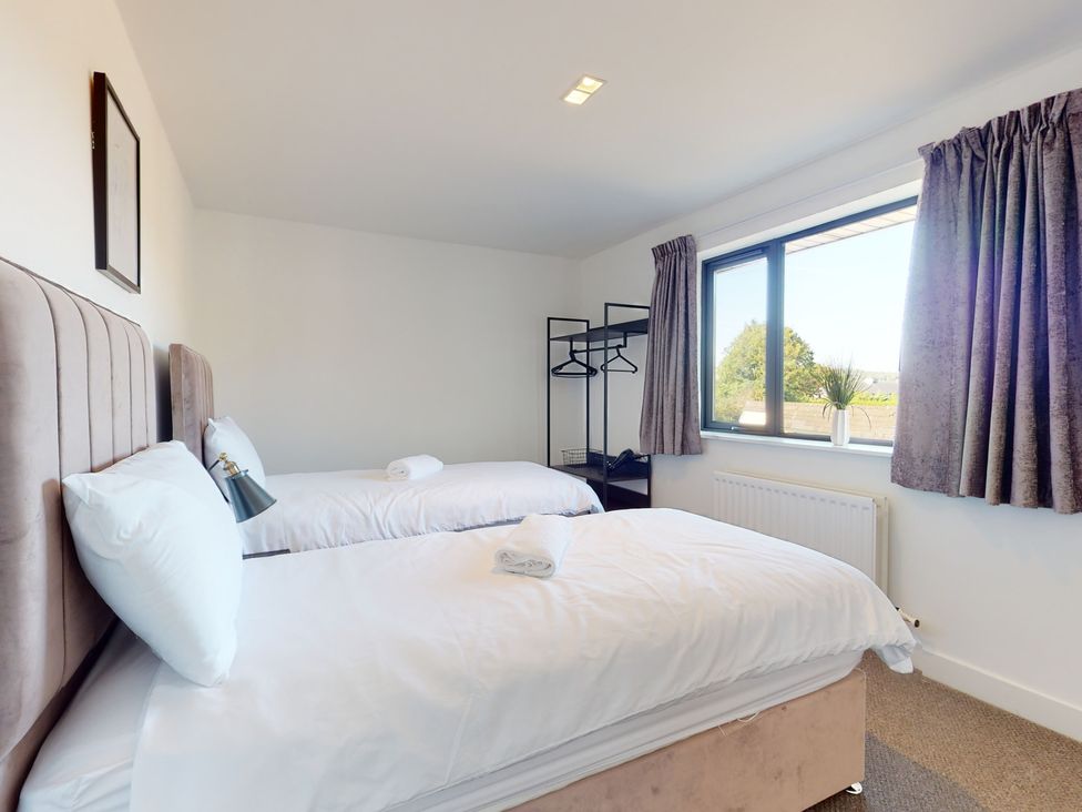 A bedroom with two beds and a window at Low Greenlands House Tewitfield