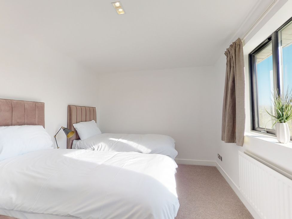 A bedroom with two beds and a window at Low Greenlands House Tewitfield