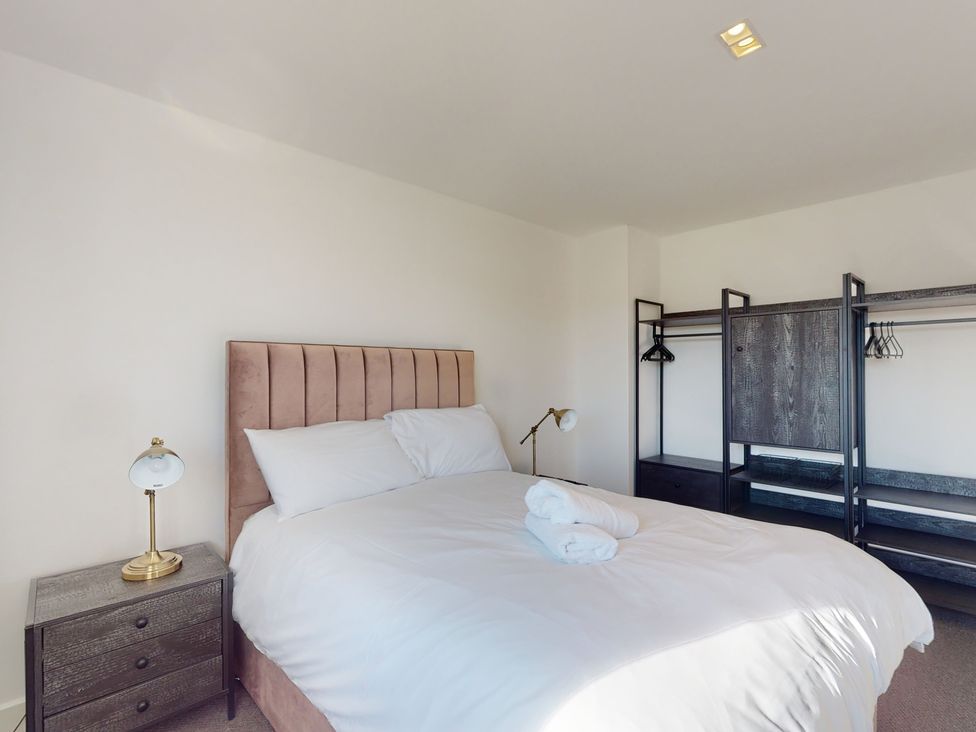 A bedroom with a bed and a wardrobe at Low Greenlands House in Tewitfield