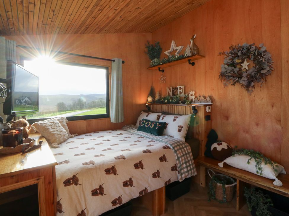 A bedroom with a bed and television at Harriet in Llangurig