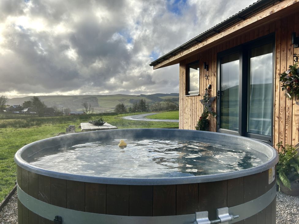 An outdoor hot tub near a wooden structure at Harriet in Llangurig