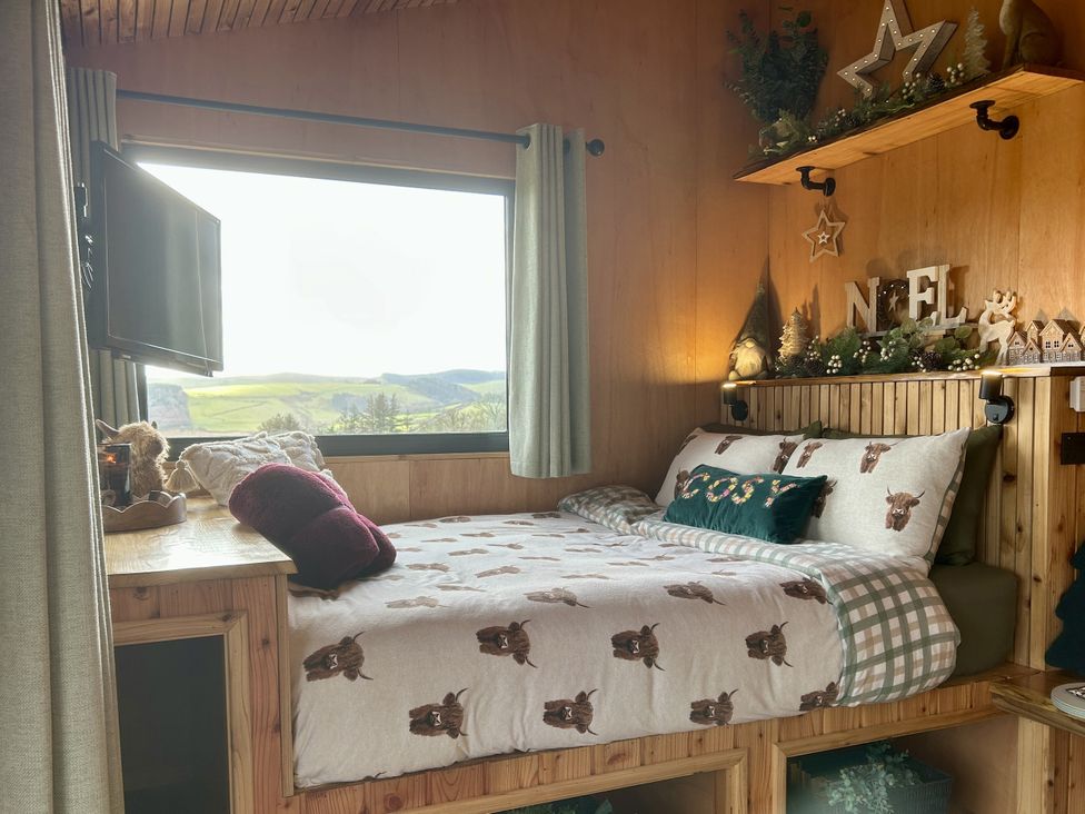 A bedroom with a bed and shelves at Harriet in Llangurig