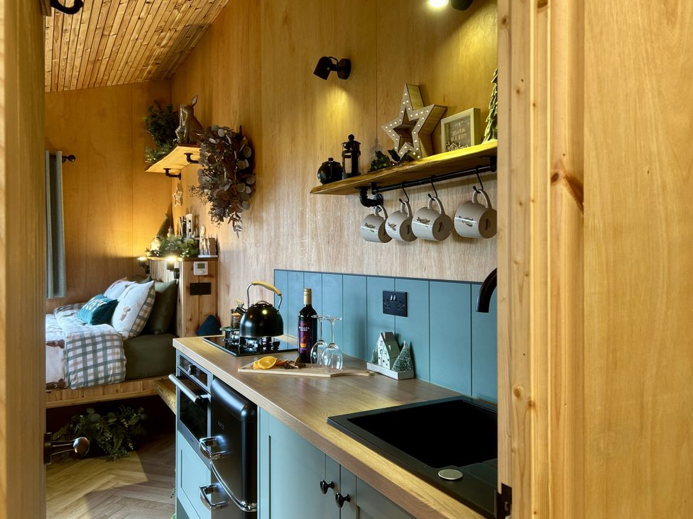 A kitchen featuring a stove, sink, and decorative items at Harriet in Llangurig