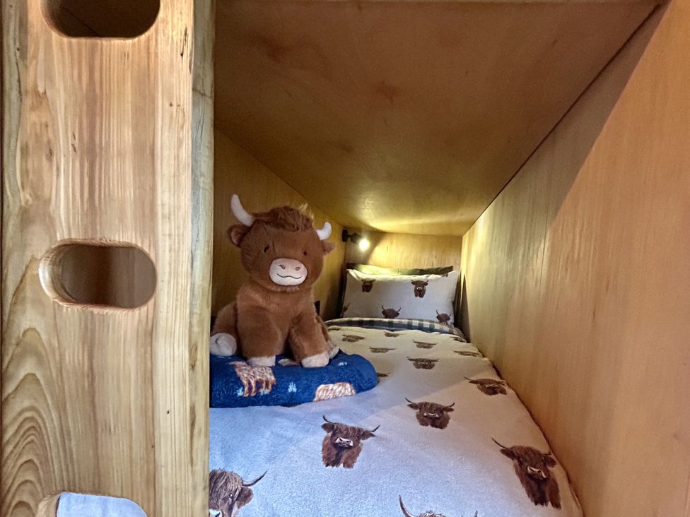 A bunk bed with a stuffed animal and patterned bedding at Harriet in Llangurig