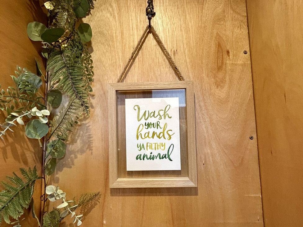 A framed sign reading 'Wash your hands ya filthy animal' in a bathroom at Harriet in Llangurig
