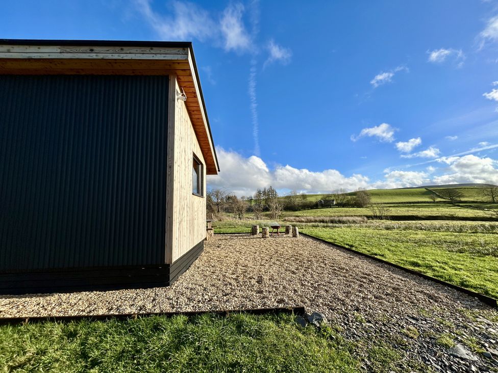 A building with gravel area and seating outside at Harriet in Llangurig
