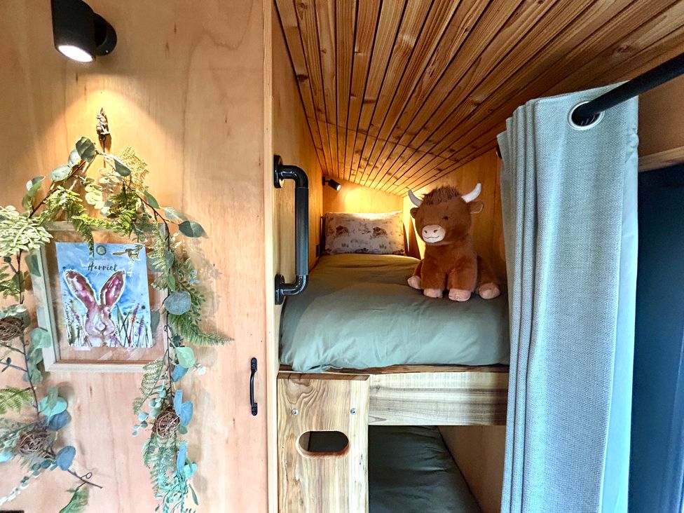 A sleeping area with a bed and stuffed animal at Harriet in Llangurig