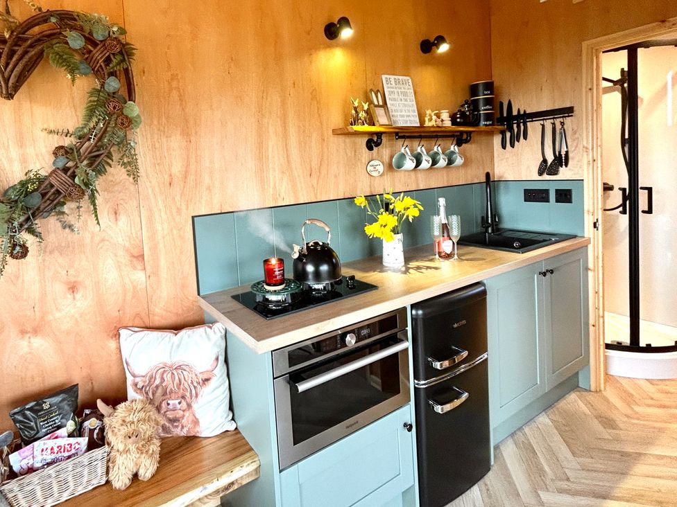 A kitchen with a kettle and flowers at Harriet in Llangurig