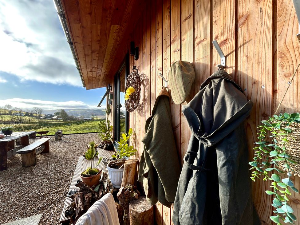 An outdoor area with coats hanging and a table at Harriet in Llangurig