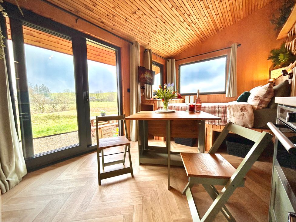 A dining area with a table and chairs at Harriet in Llangurig
