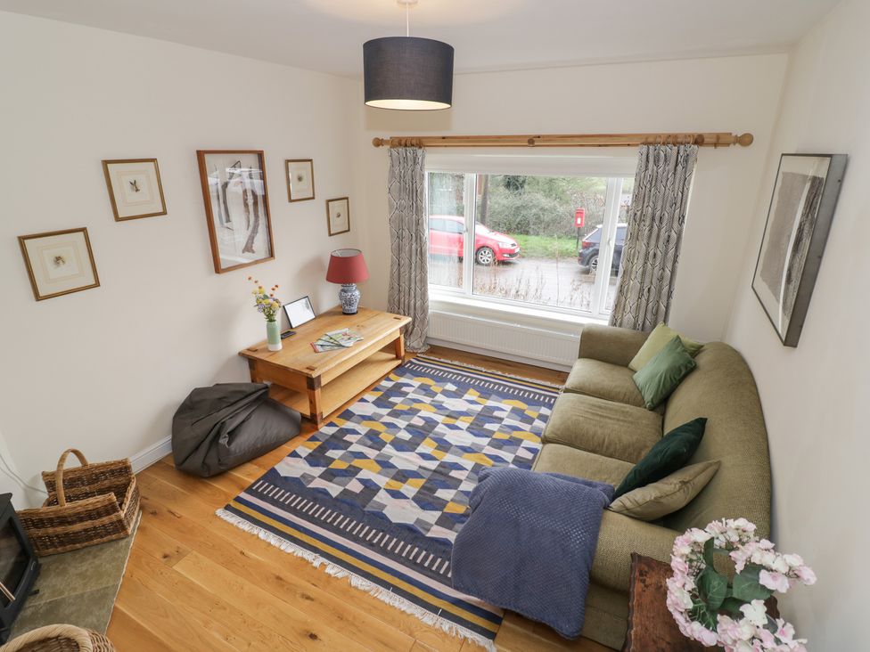 A living room with a green sofa and coffee table at The Woods