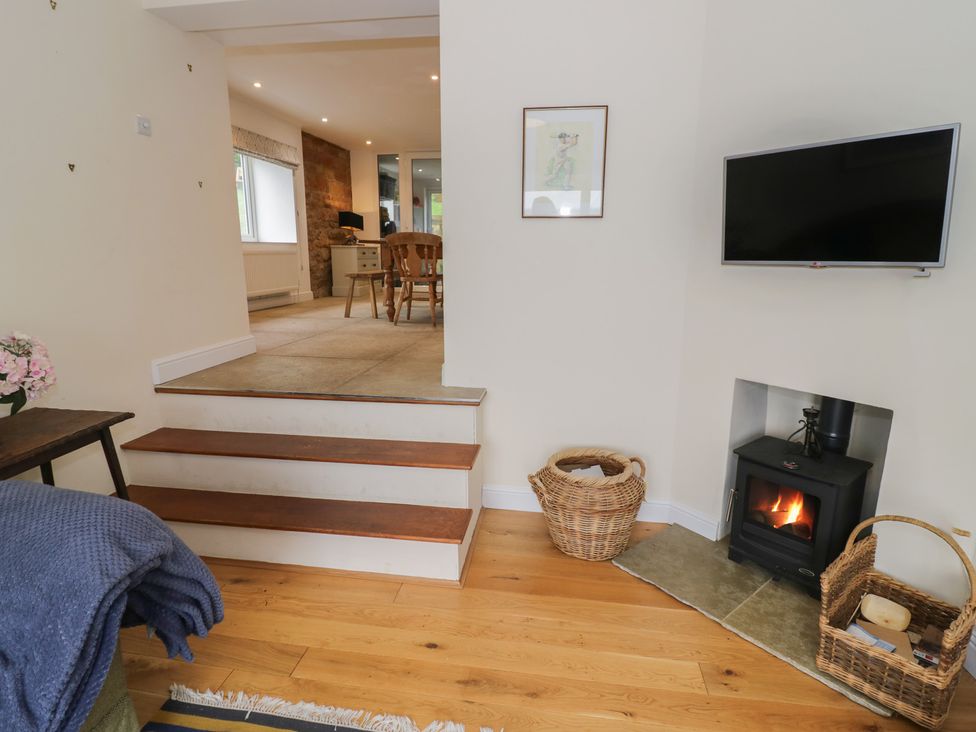 A living room with a fireplace and television at The Woods in 