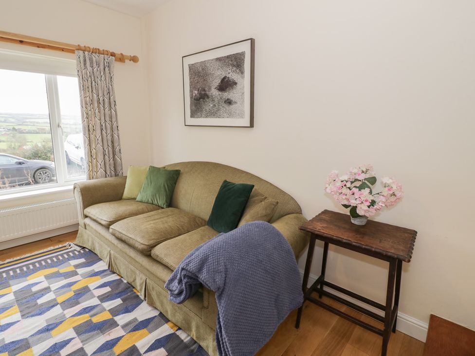 A living room with a sofa and a table with flowers at The Woods in 