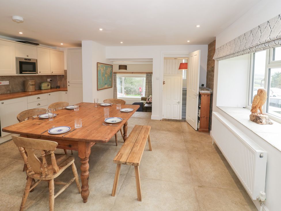 A kitchen with a dining table and chairs at The Woods
