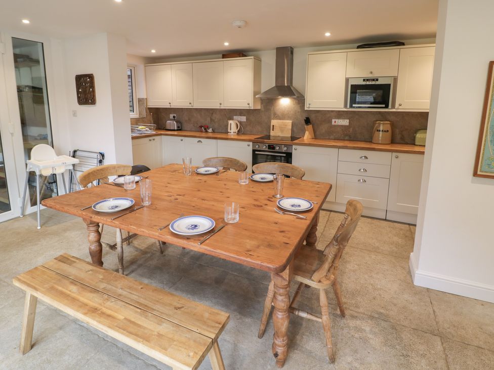 A kitchen with a wooden table and chairs at The Woods 