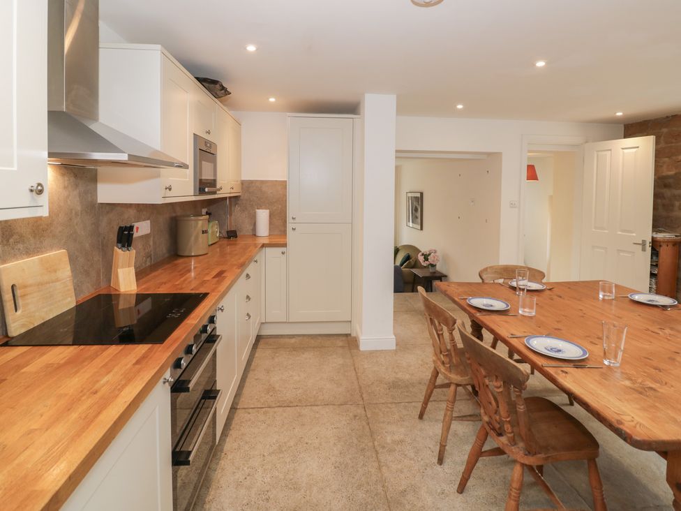 A kitchen with a dining table and chairs at The Woods