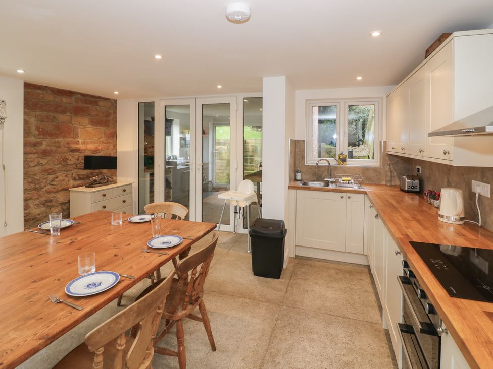 A kitchen with a dining table and appliances at The Woods in 