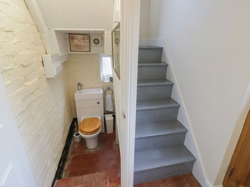 A bathroom with a toilet and sink next to staircase at The Woods