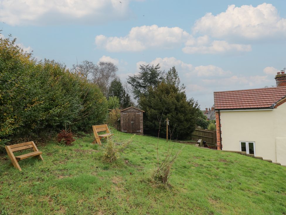 A garden with a shed and benches at The Woods 