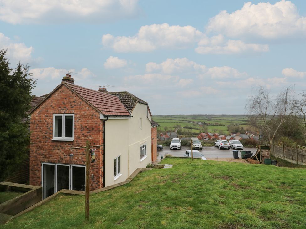 A house with cars parked nearby at The Woods in 