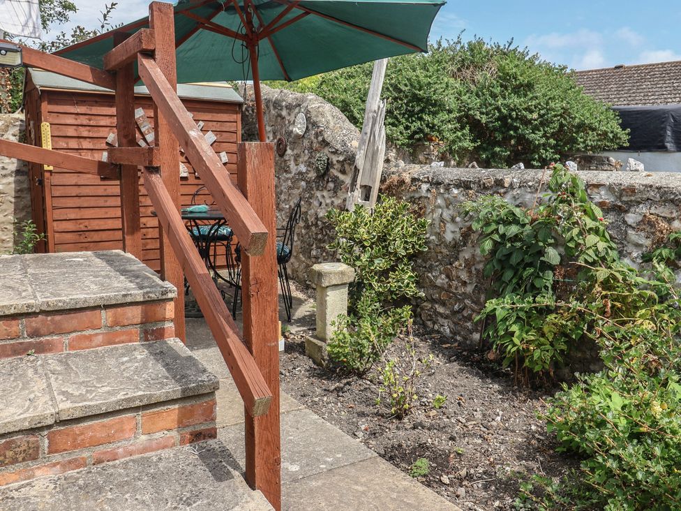 A garden with a staircase, table, and chairs at Garden Studio at Stanley House in Charmouth