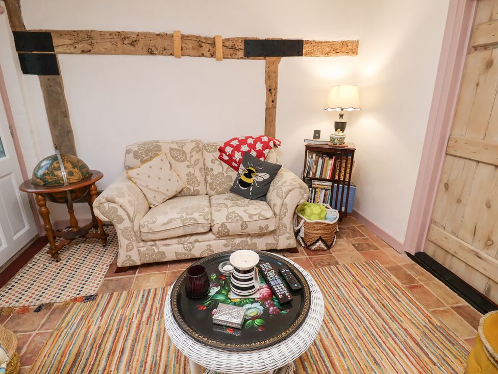 A living room with a sofa and table at The Hare & the Bumblebee Cottage