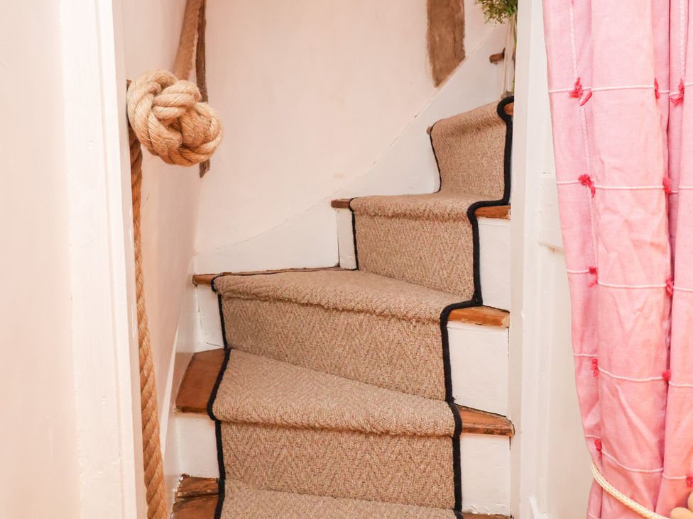 A staircase with carpet and rope at The Hare & the Bumblebee Cottage