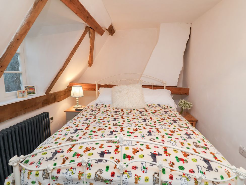 A bedroom with a bed and wooden beams at The Hare & the Bumblebee Cottage