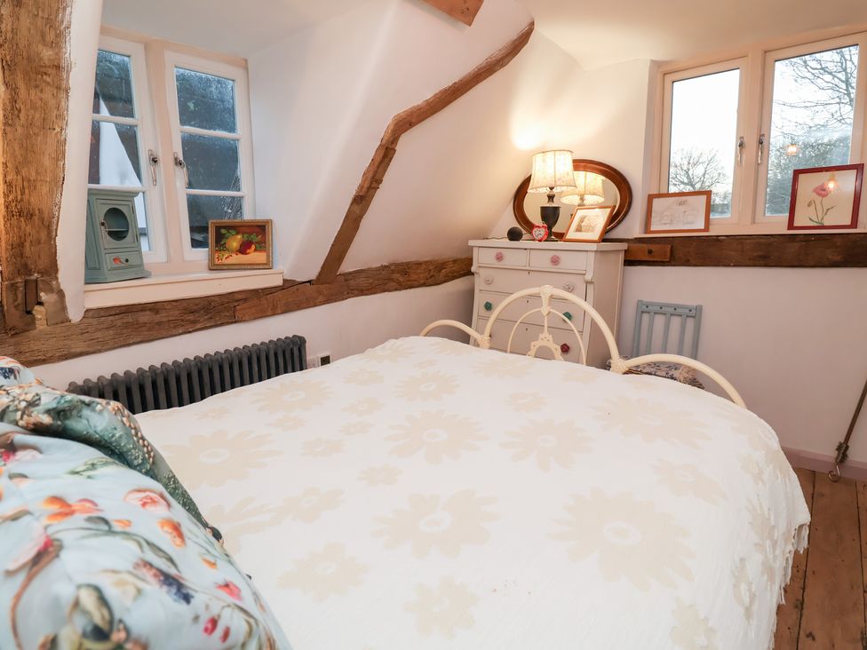 A bedroom with a bed and decorative items at The Hare & the Bumblebee Cottage