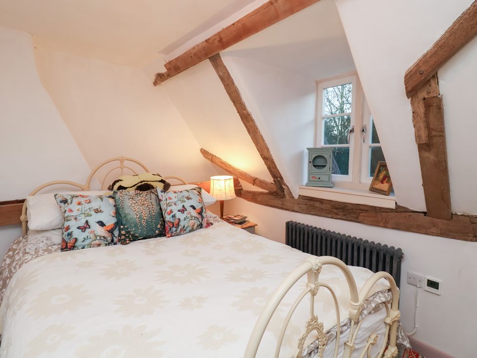 A bedroom with a bed and window at The Hare & the Bumblebee Cottage