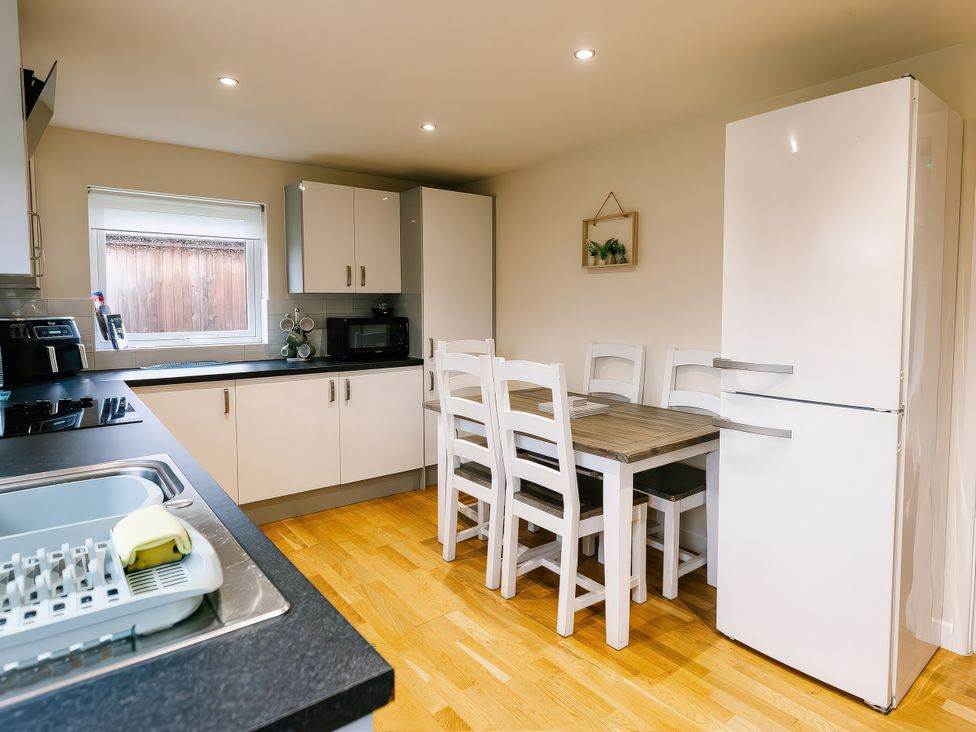 A kitchen with a table and chairs at Aspen Lodge in Brigg