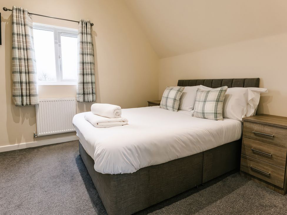 A bedroom with a double bed and two pillows at Aspen Lodge in Brigg