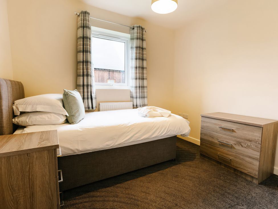 A bedroom with a bed and a chest of drawers at Aspen Lodge in Brigg