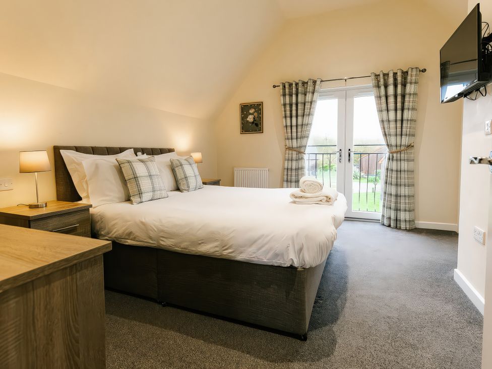 A bedroom with a bed and television at Aspen Lodge in Brigg