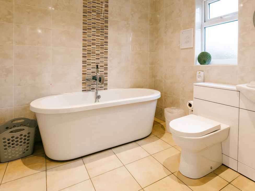 A bathroom with a bathtub and toilet at Aspen Lodge in Brigg