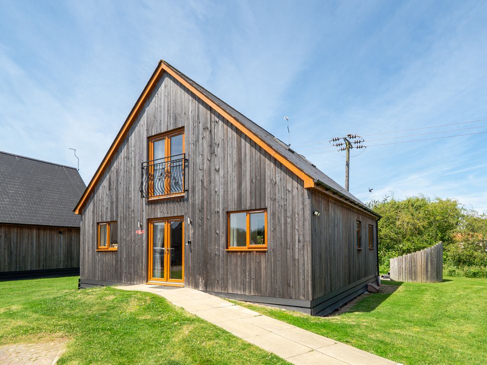 A house with wooden exterior and balcony at Aspen Lodge Near Brigg