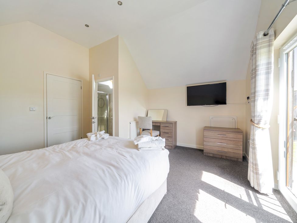 A bedroom with a bed and a dresser at Aspen Lodge Near Brigg