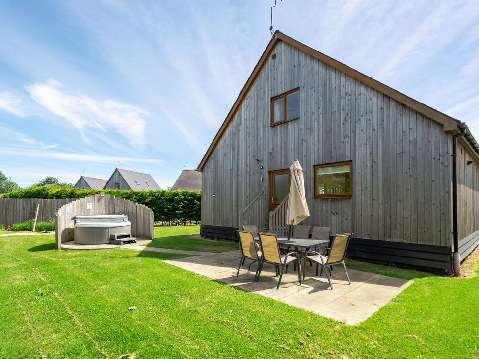 A house with a hot tub and patio furniture at Aspen Lodge near Brigg