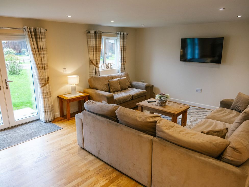A living room with sofa and television at Sage Lodge in Brigg
