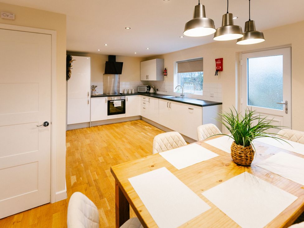 A kitchen with a dining table and chairs at Sage Lodge in Brigg